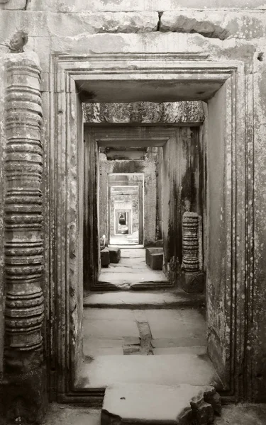 Harap olmuş eski bir binada uzun bir taş koridor. Boş kapı.