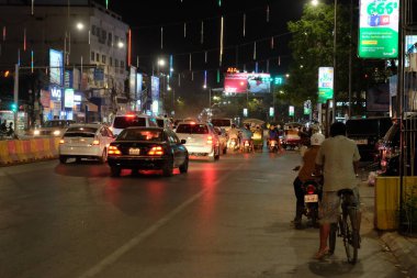 Siem Reap, Kamboçya, 23 Aralık 2018 Araçlar trafik ışığında bekliyor. Geceleyin yoldaki bisikletçiye. Asya şehrinin gece trafiği.