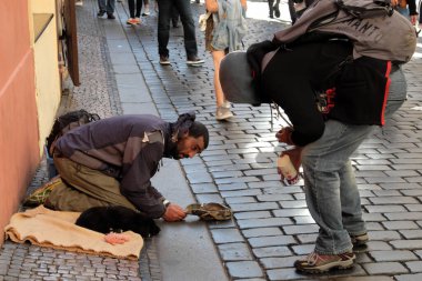 Prag, Çek Cumhuriyeti, 12 Ekim 2019. Bir adam dilenci bir göçmenle konuşuyor..