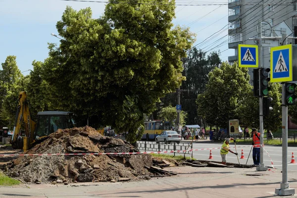 Chernihiv, Ukrayna, 7 Haziran 2019. Yol çalışmaları sırasında büyük bir toprak yığını yakınında bir kazıcı..