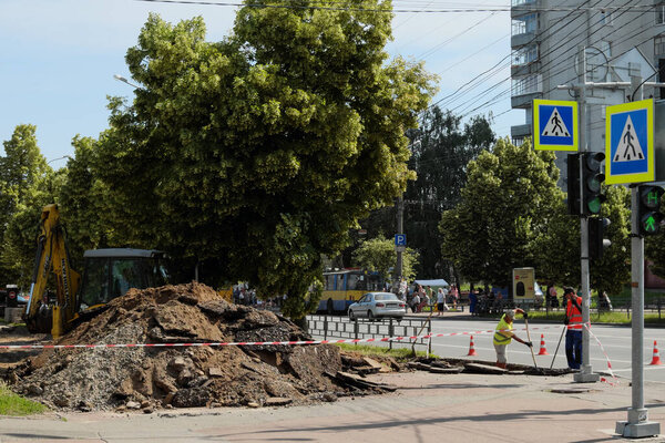 Chernihiv, Ukraine, June 7, 2019. An excavator near a large pile of land during road works.