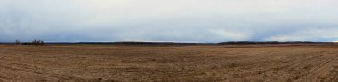 Bulutlu bir akşamda tarlayı sürdüm. Tarım endüstrisi manzarası. Panorama.