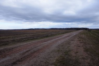 Akşamları tarlaların arasında toprak bir yol. Sonbahar manzarası.