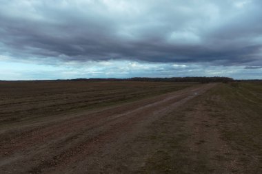 Akşamları tarlaların arasında toprak bir yol. Sonbahar manzarası.