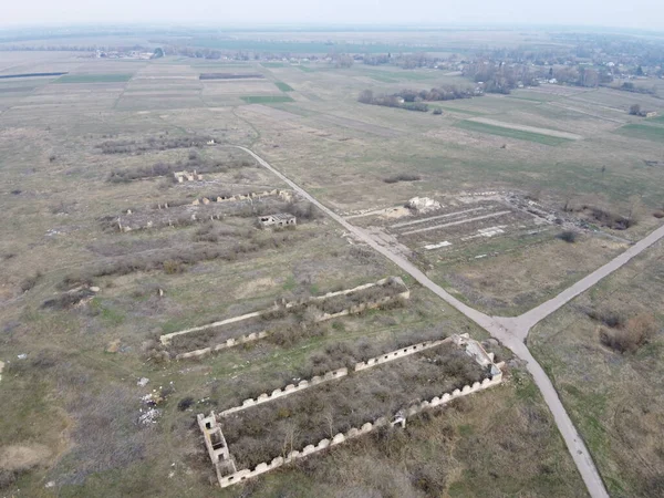Destroyed agricultural buildings, aerial view. Abandoned livestock farm.