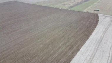 Traktör tarlayı sürüyor, hava manzarası var. Tarım arazisi.