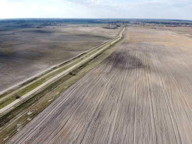 İki tarlanın arasındaki toprak yol, hava manzaralı. Tarım arazisi.