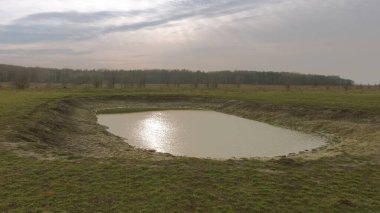 Küçük yapay sığ su deposu. Çok güzel renkli bir gölet. Bahar manzarası.