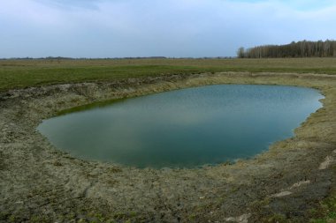 Küçük yapay sığ su deposu. Çok güzel renkli bir gölet. Bahar manzarası.