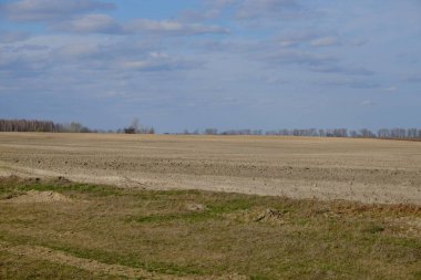 Çiftlik arazisi üzerinde bulutlu güzel bir gökyüzü. Bahar manzarası.