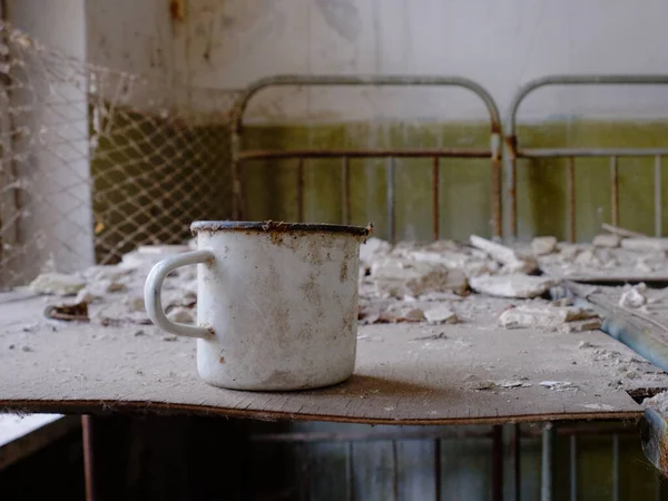 切尔诺贝利一座废弃建筑床上的一个白色金属杯子 — 图库照片