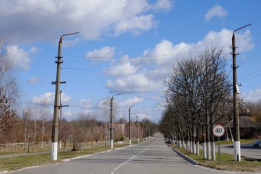 Uzun düz bir yol. Yol boyunca lamba direkleri. Güzel bulutlu gökyüzü. Çernobil yolu..