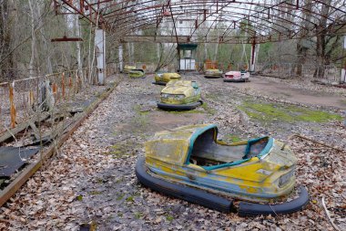 Pripyat 'ta terk edilmiş bir lunaparkta arabalar. Paslı terk edilmiş eğlenceler.