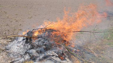 Açık havada büyük bir şenlik ateşi. Yanmış tahta ve dallardan bir kül yığını. Sıcak alev.