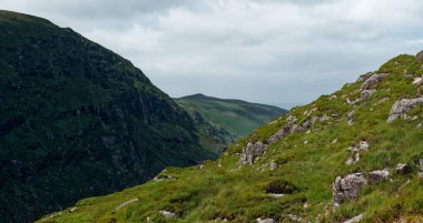 Looking down the lush green valley of the Gap of Dunloe, County Kerry, Ireland during an overcast day in summer.