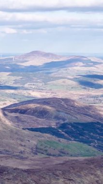 Get a great view of the Irish countryside near Priest's Leap from high up. The landscape is rolling and there is some cloud in the sky.