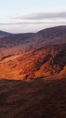 Golden hour light in Ireland, showing barren landscape and gentle slopes.