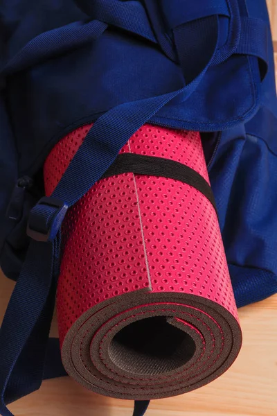Pink yoga mat in a blue gym bag. Set for fitness, yoga and massage.