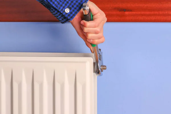 Hand of a man, repairman, installation repair radiator valve closeup