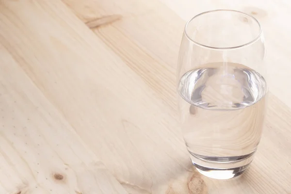 Immagine Mezzo Bicchiere Pieno Acqua Piedi Tavolo Legno — Foto Stock