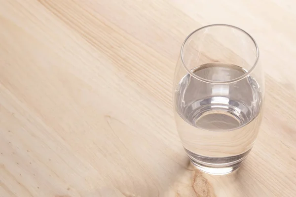 Immagine Mezzo Bicchiere Pieno Acqua Piedi Tavolo Legno — Foto Stock