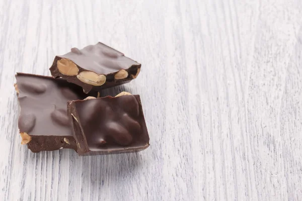 Fette Delizioso Cioccolato Fondente Con Noci Tavolo Legno Bianco Macro — Foto Stock