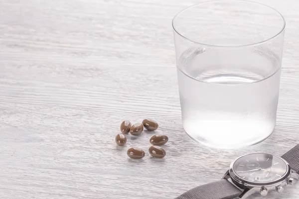 Bicchiere Appannato Acqua Capsule Mediche Marroni Vecchio Tavolo Legno Bianco — Foto Stock