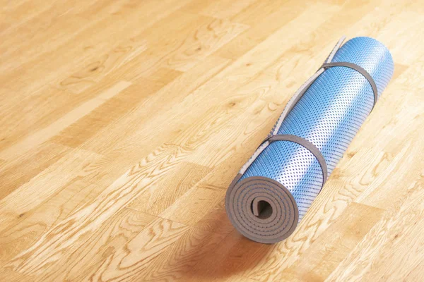 Mavi yoga mat kadar yere yuvarlandı. Sağlıklı yaşam konsepti