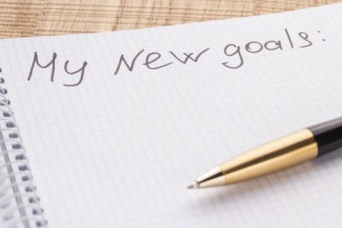 Üstten görünüm işyeri defter ve kalem ahşap masa arka plan, retro etkisi üzerinde. Yazıt yeni benim hayatımdır. Güncelleştirme ve insanların değişen kavramı