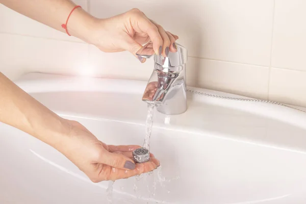 Vinç aerator tamiri. Mevduat üzerinden aerator Temizleme. Kızın elini su ile Mikser bir kirli kireçtaşı aerator yıkar..