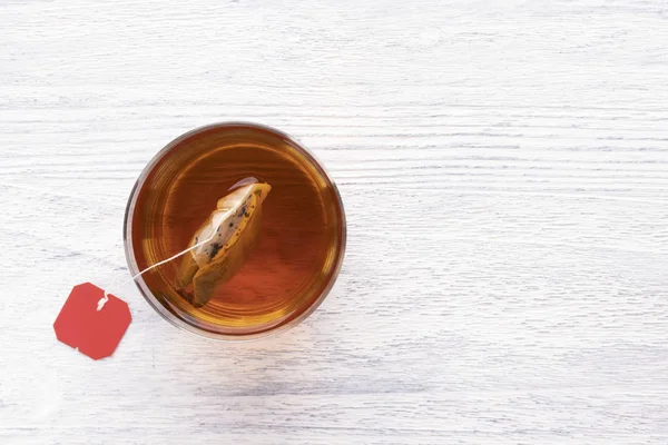 Sacchetto Una Tazza Vetro Trasparente Con Acqua Calda Tavolo Legno — Foto Stock