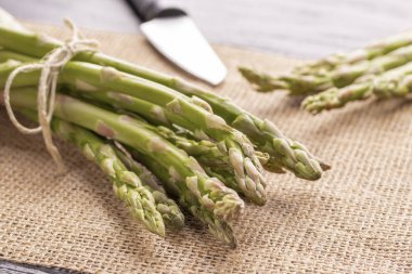 Parlak bir bıçak ile bir tabloda taze yeşil kuşkonmaz. Sağlıklı gıda.