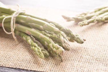 Taze yeşil kuşkonmaz eski mutfak masası ve bir peçete. Sağlıklı doğal gıda.