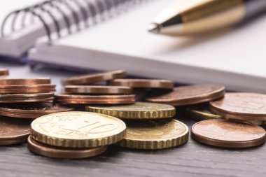 Euro euro sikkeleri üzerinde eski siyah ahşap masa yığını. Kalem, defter. Ev giderleri planlama ve faturalar, muhasebe kavramı