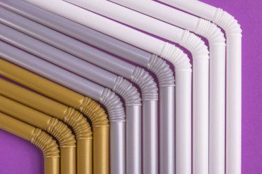 Renkli plastik çöp sıkıca içme birbirlerine karşı mor bir tabloda, arka plan olarak yakın çekim preslenmiş.