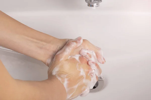 Подросток моет руки с мылом в раковине в ванной. . — стоковое фото