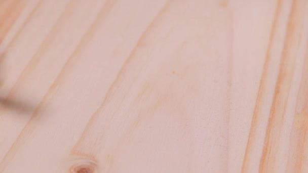 Las semillas de lino caen de arriba sobre una mesa de madera — Vídeo de stock