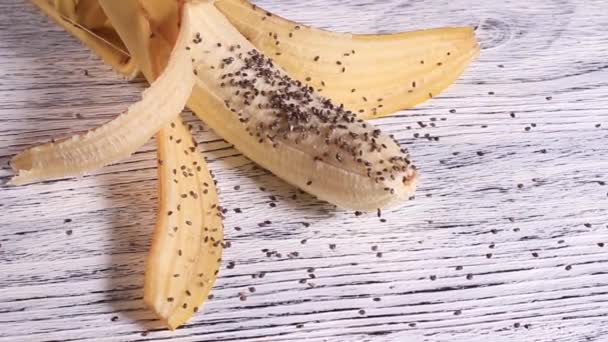 皮をむいたバナナに積まれたチアシード — ストック動画
