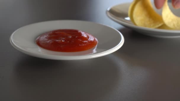 男はスパイシーなトマトソースでポテトチップスを食べ それぞれジューシーです 灰色のテーブルの上食べ物は白い皿の中にある — ストック動画