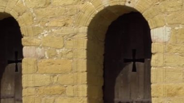 Oyma haç ile ahşap panjur ile kemerli pencereler. Bulutlar ile eski bir İspanyol kilisesi, ağaçlar ve gökyüzü görünümü