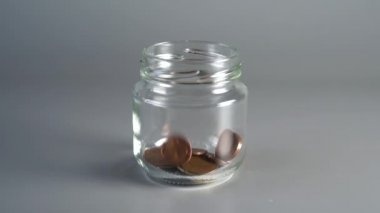 Madeni paralar bir tasarruf bankasına düşer ve aşırıya düşer. Vergi ve kredi ödemek için para toplama kavramı. yavaş çekim