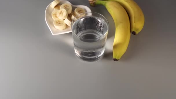 Cortado Rodajas Plátanos Enteros Plato Blanco Sobre Fondo Gris Niebla — Vídeos de Stock