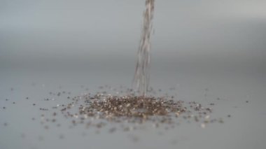 Chia tohumları yukarıdan gri bir arka plan üzerine düşmek ve farklı yönlere dağılım. Seçici odak. Yavaş çekim