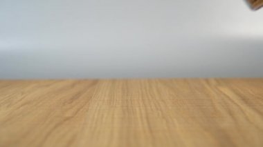 Adamın eli cam bardaktan tahta bir masaya bir sürü kedi maması döküyor.