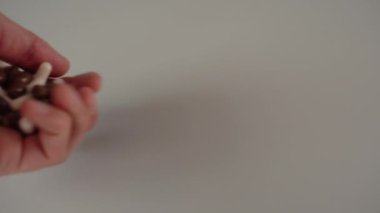 El gri arka plan üzerinde avuç kahverengi ve beyaz tıbbi kapsül dışarı dökülür