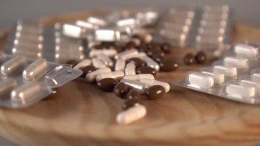 Bir adamın eli, bir yığın uyuşturucu ve kapsül yığınının ahşap yüzeyinden süpürüp, yeri temizliyor. Çekiş tedavisinin reddi kavramı. Yavaş çekim