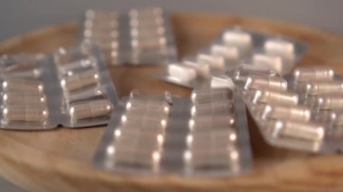 Bir adamın eli, bir yığın uyuşturucu ve kapsül yığınının ahşap yüzeyinden süpürüp, yeri temizliyor. Çekiş tedavisinin reddi kavramı. Yavaş çekim