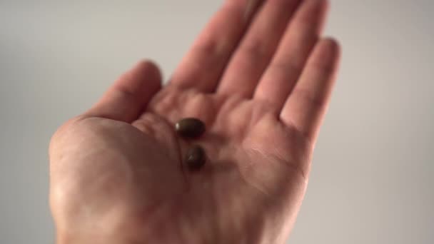 Drie Donkere Medische Capsules Gieten Uit Een Handpalm Een Grijze — Stockvideo