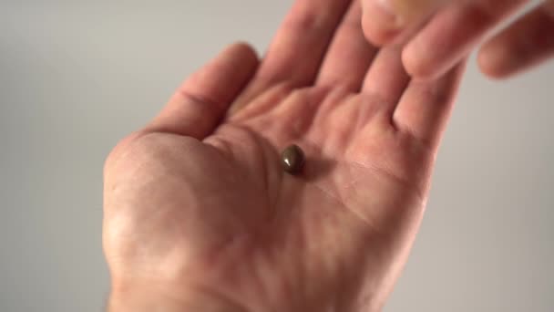 Nimmt Eine Hand Eine Medizinische Braune Kapsel Aus Seiner Handfläche — Stockvideo
