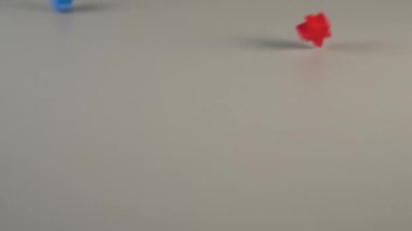 Çok renkli figürler gri bir arka plan üzerinde yukarıdan düşmek ve farklı yönlere sıçrama. Çok uluslu kurum ve kuruluşlar kavramı